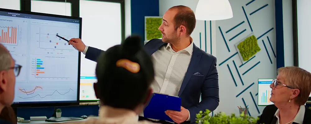 Man som pekar på presentation av siffror och diagram