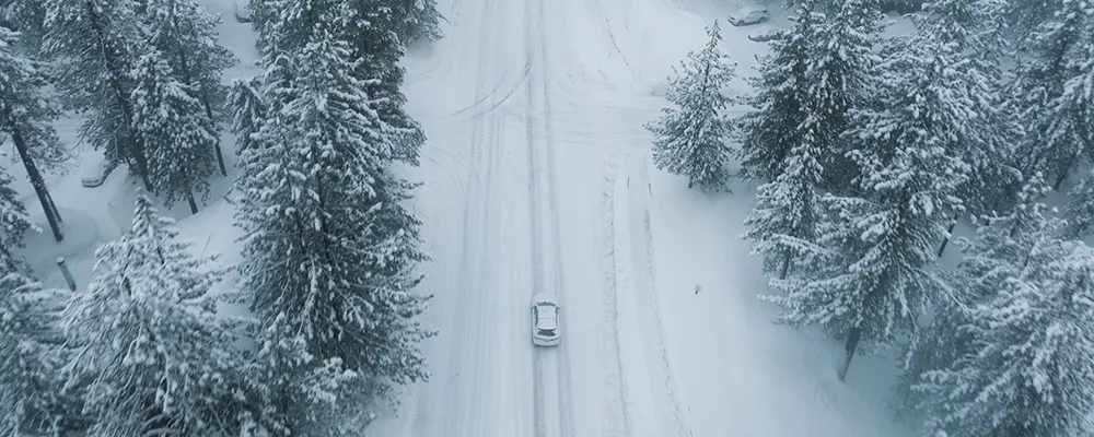 Bil som kör på väg i snöigt väder