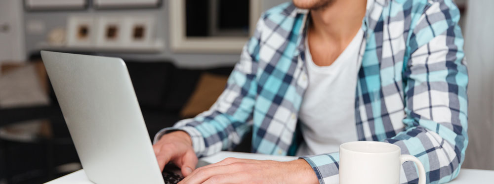 Man med laptop läser om ledarskap